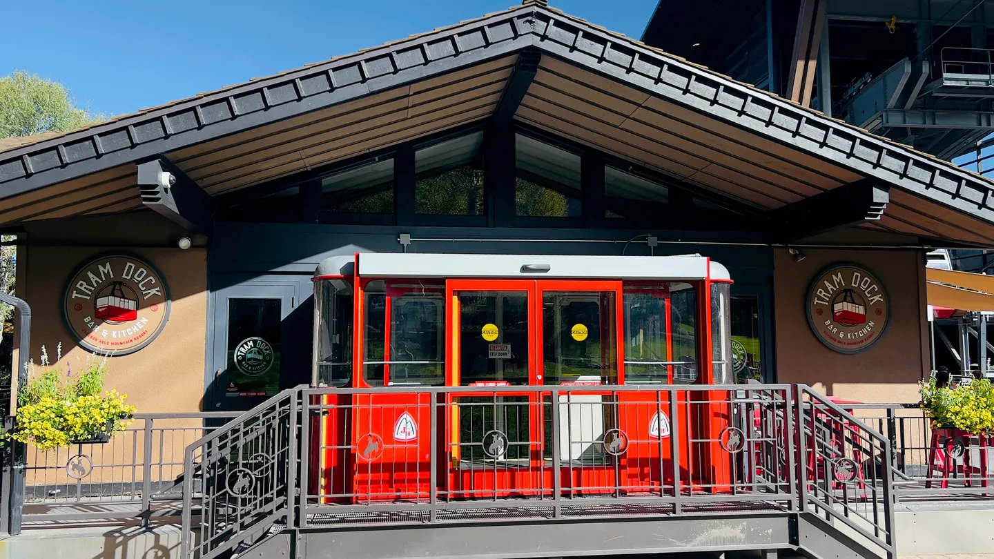 The Tram Dock Bar & Kitchen badge on the building, on either side of a red cabin at the entrance.