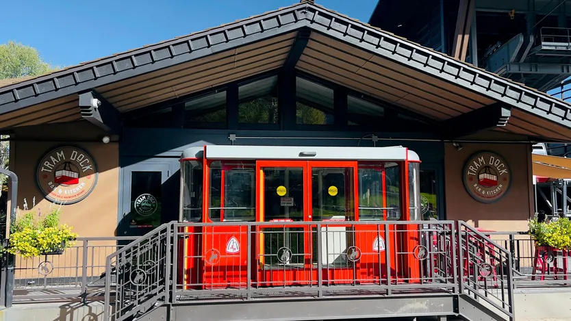 The Tram Dock Bar & Kitchen badge on the building, on either side of a red cabin at the entrance.